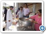 Fazal Jassat and Farouk Adam and Imraan Nathie of the Kuraby Mosque with Amina Adam stirring the pot
